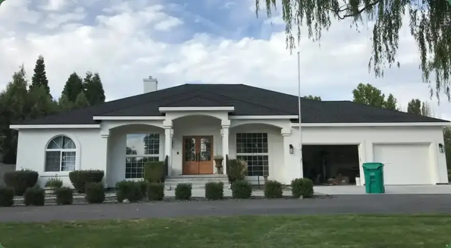 White stucco home with a new black roof