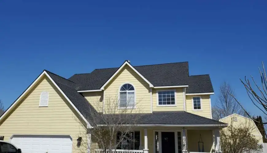 Yellow two-storey home with lap siding and a dark roof